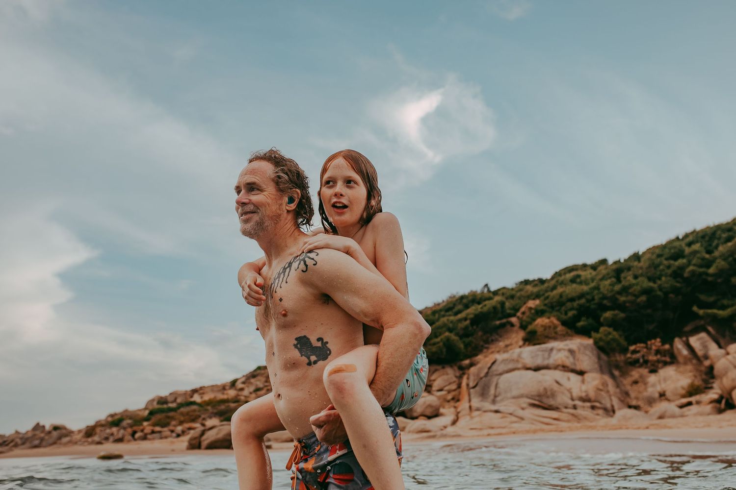 Dad giving son a piggyback at the beach in Adelaide, South Australia