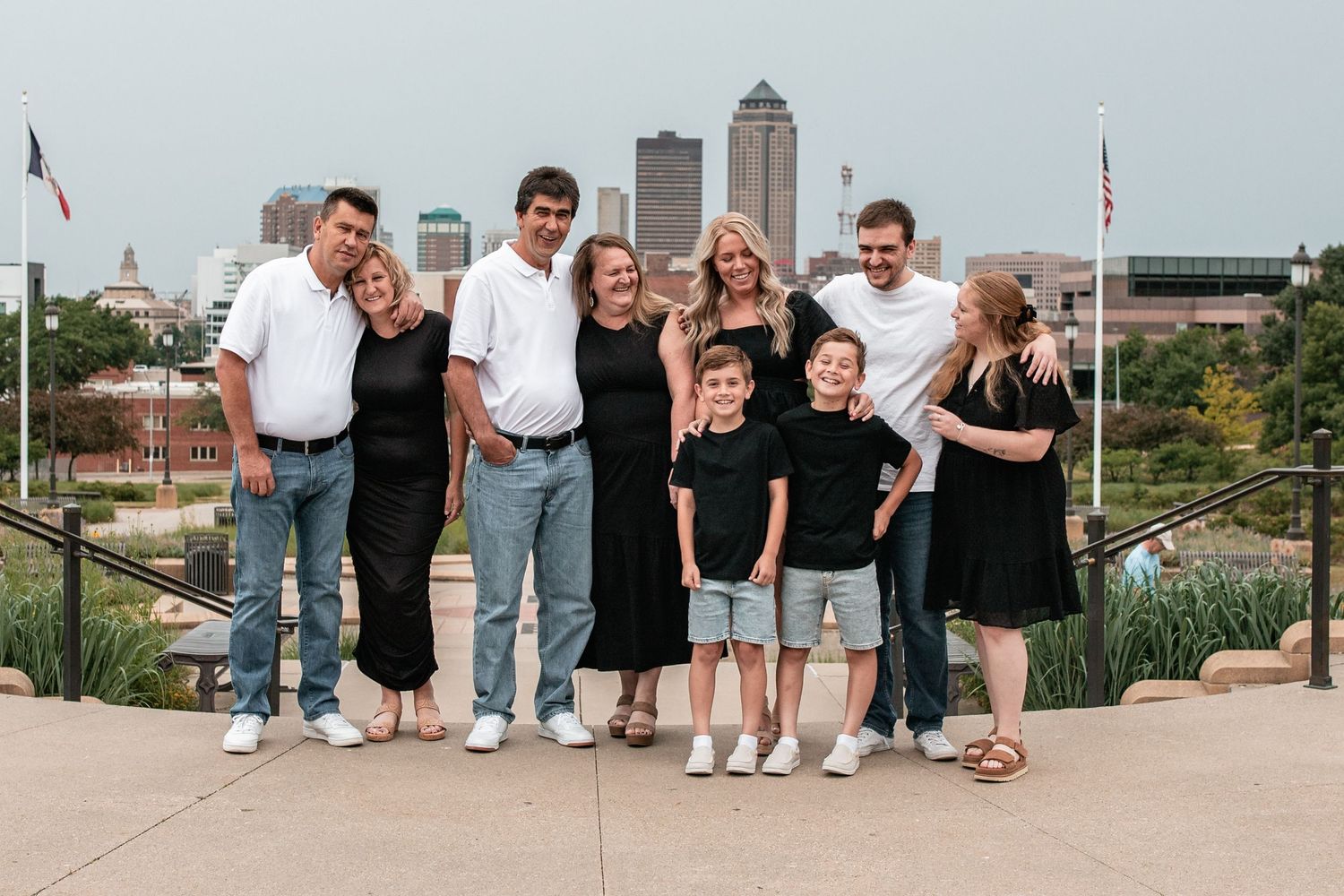 Family group poses together on outdoor terrace with city skyline in background.