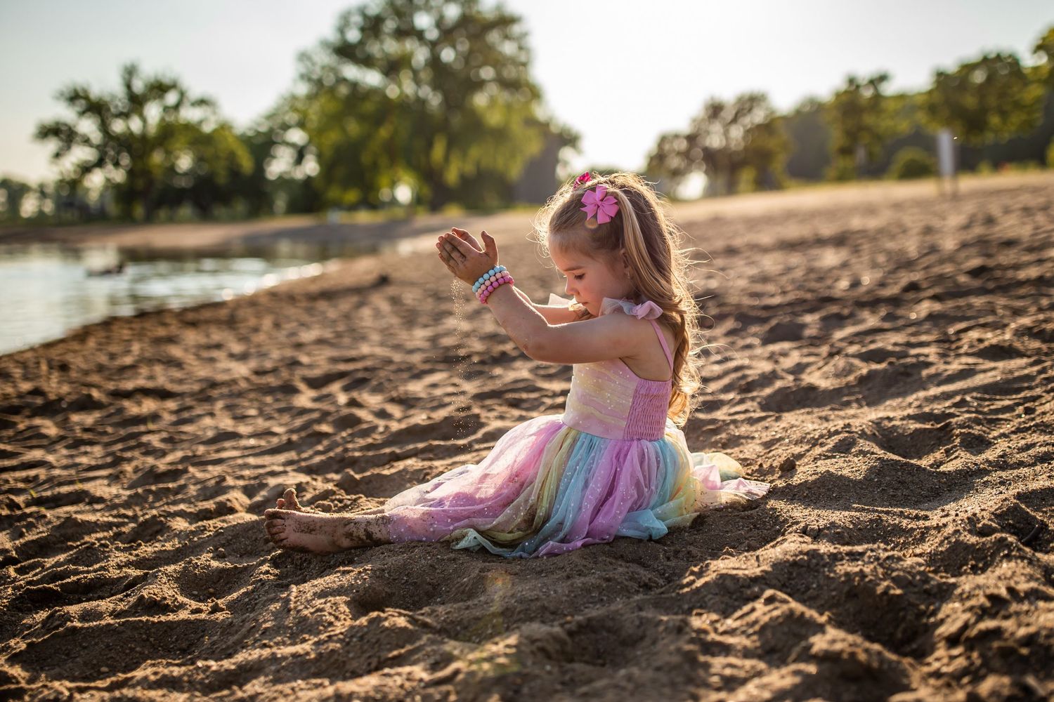 Silhouette photos at sunset showing a child playing on sandy beach.
