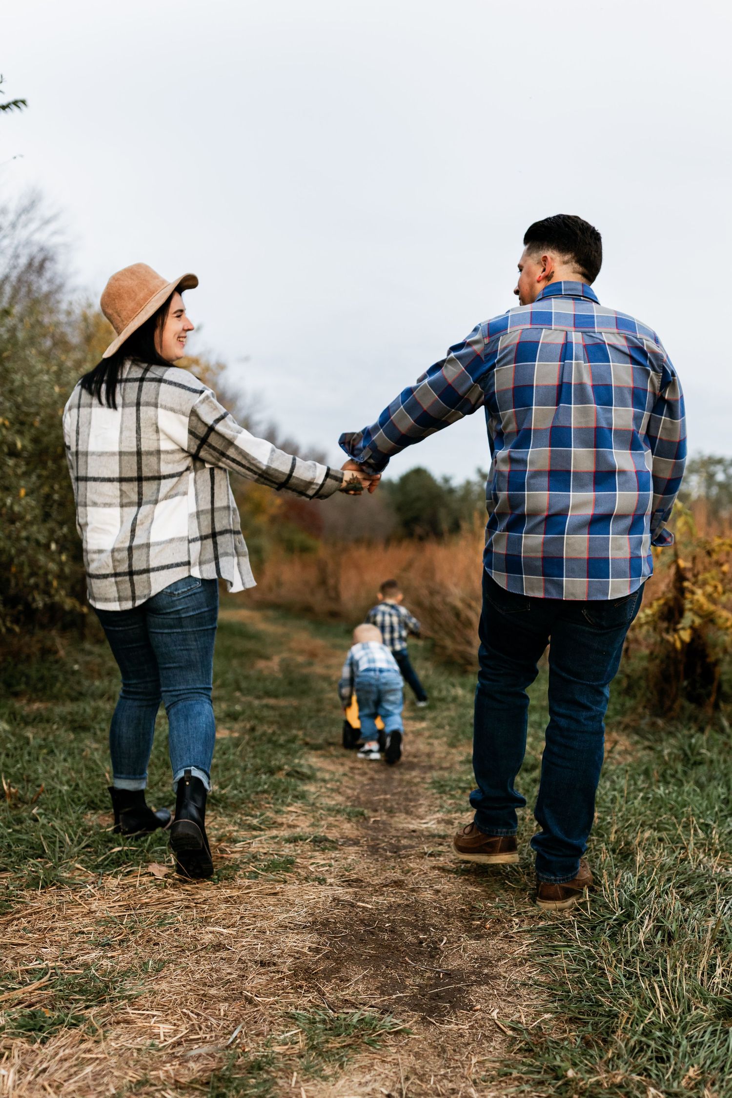 A series of photos showing two people walking together on a grassy path during autumn.