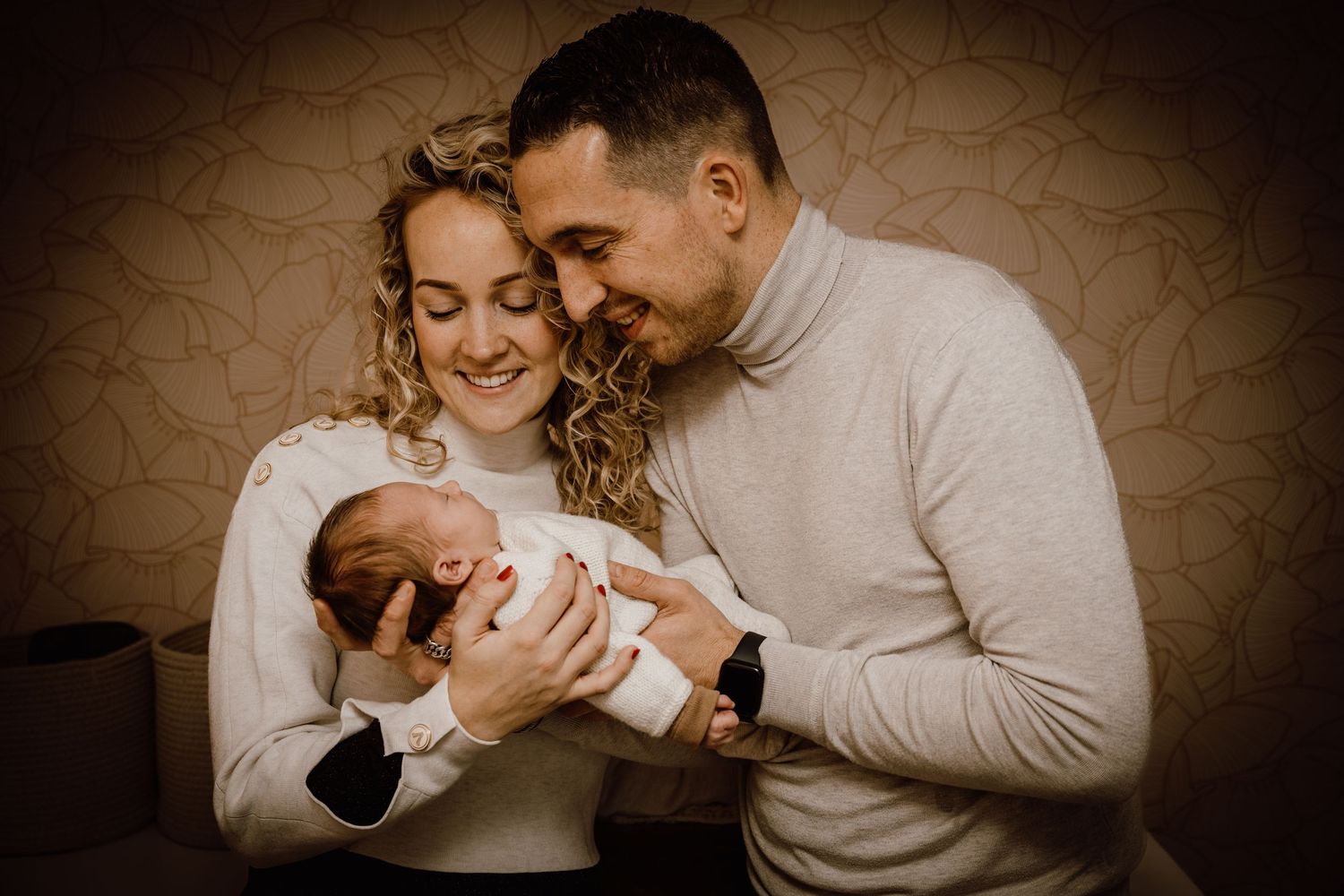 Intimate family lifestyle photography session in warm sepia tones with a newborn baby.