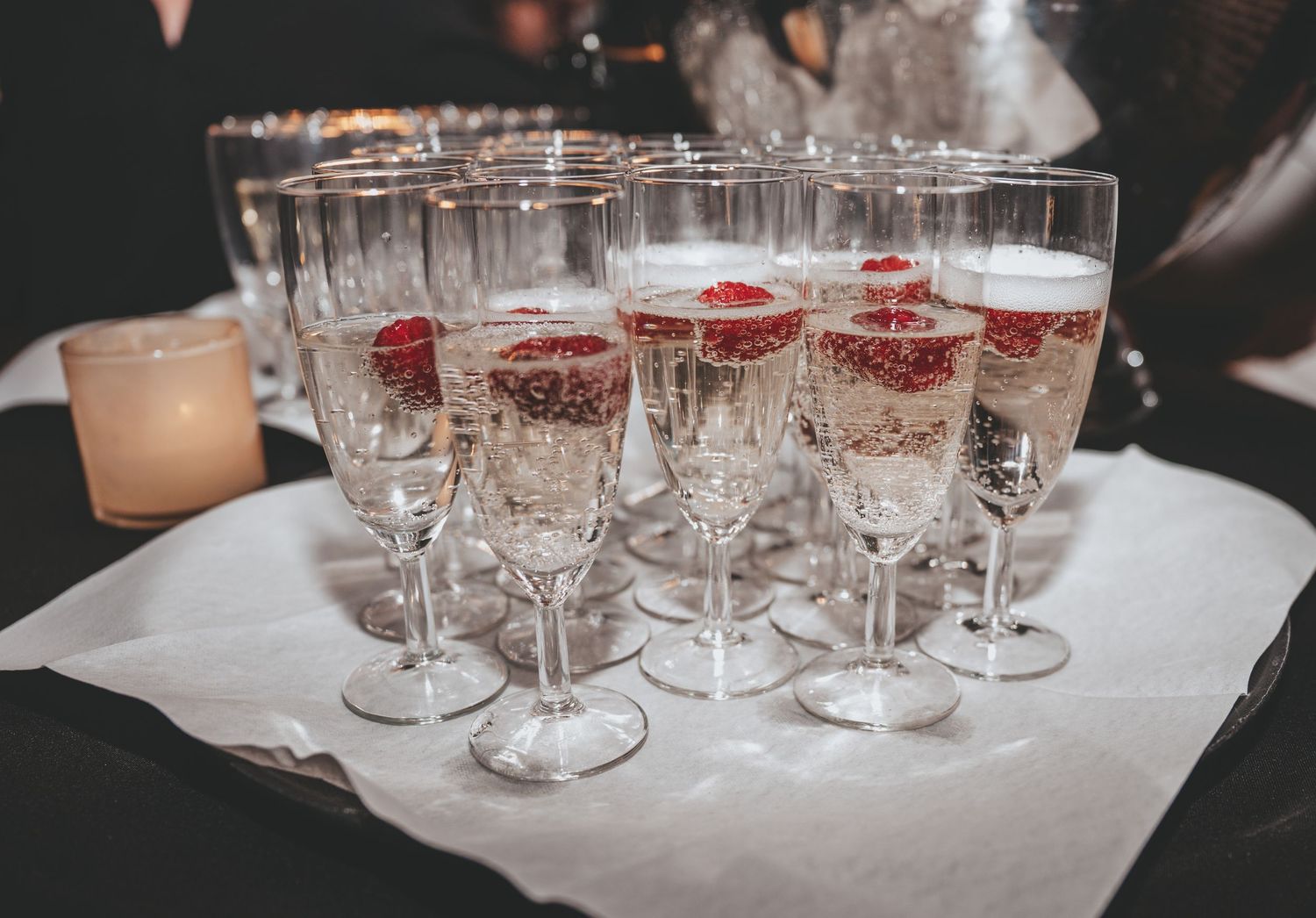 Collection of empty wine glasses arranged on white linens for a formal event.