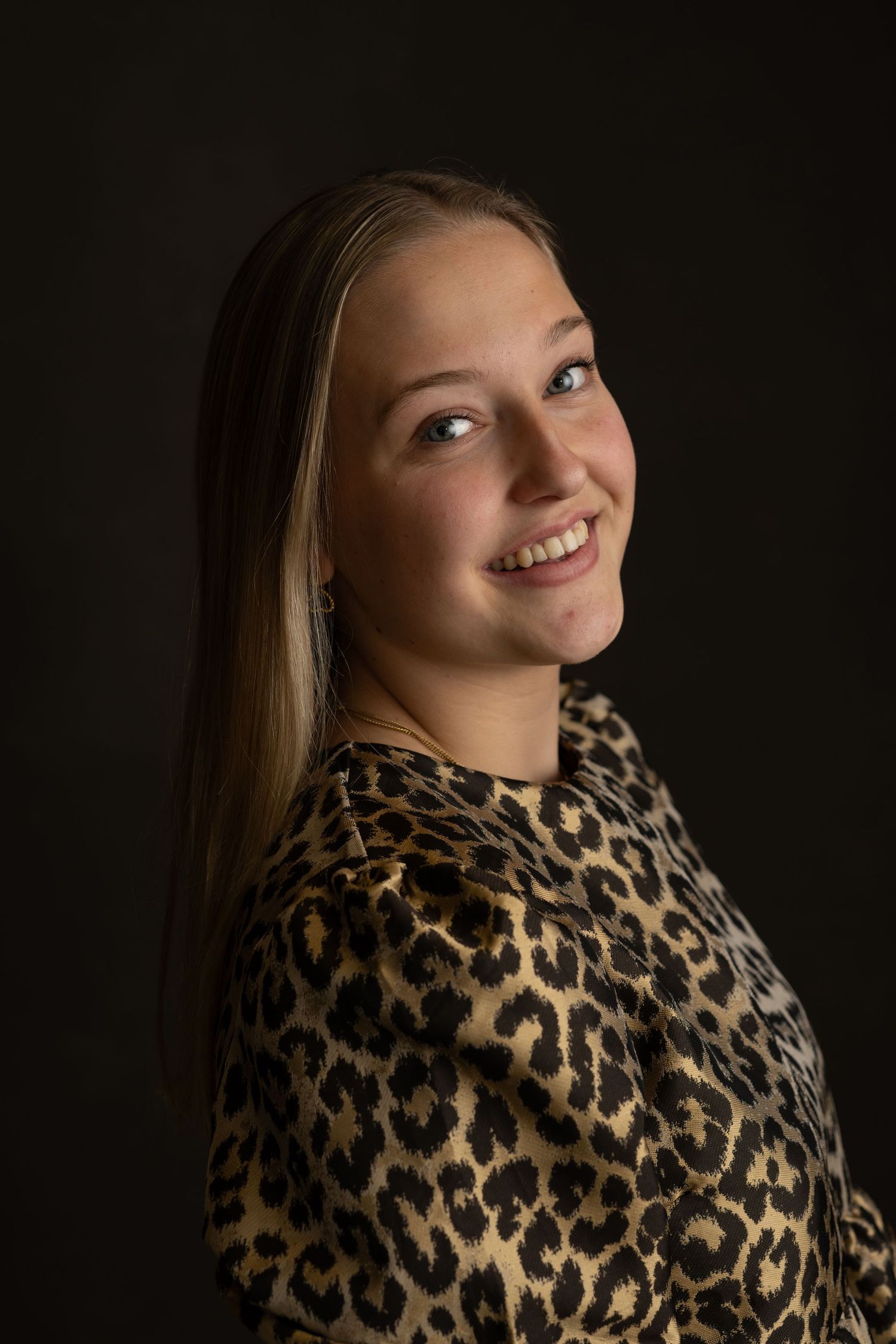 Portrait series featuring leopard print top with warm lighting against dark background.