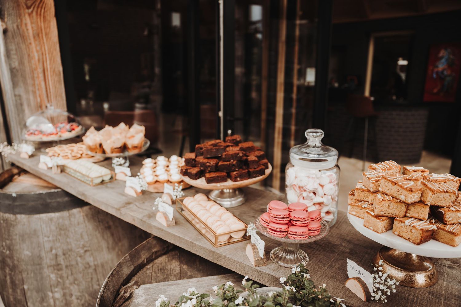Rustic wedding dessert table featuring an assortment of cookies and baked treats.