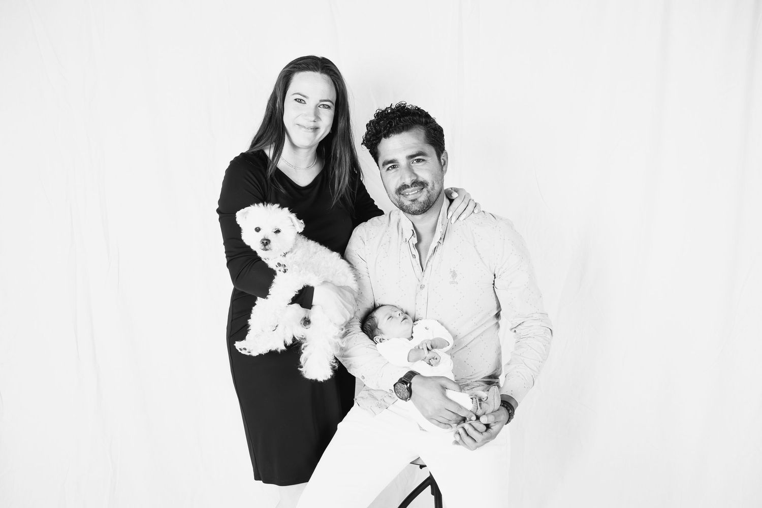 Family portrait session against white background showing playful interactions.