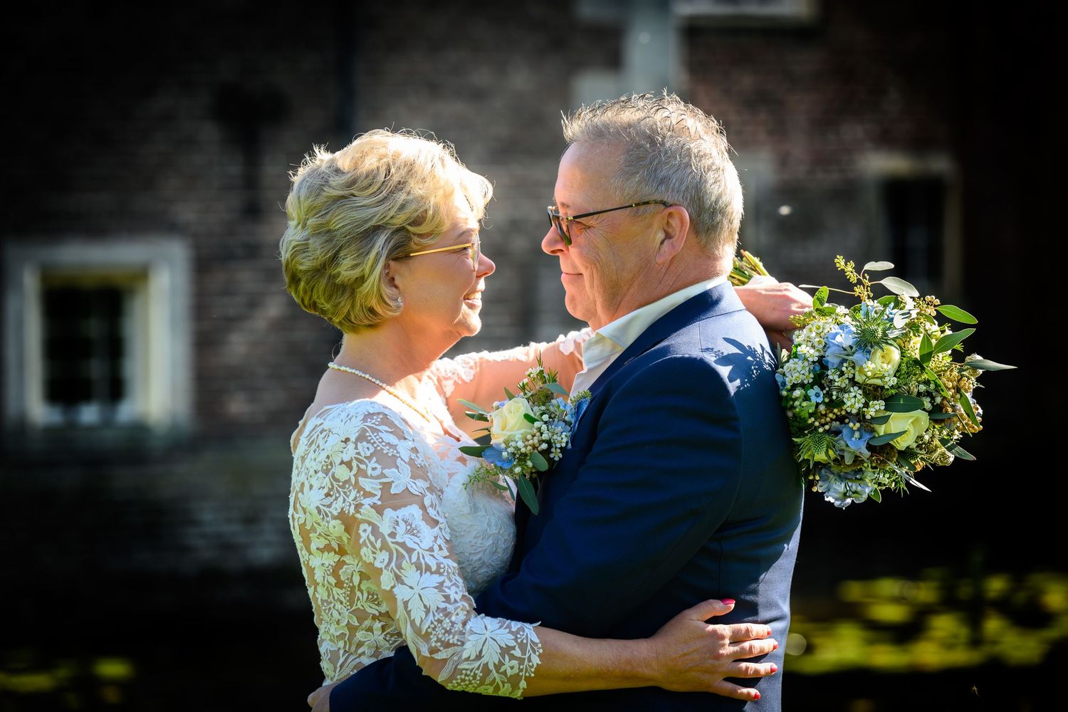 Romantic embrace during an outdoor wedding with natural garden backdrop.