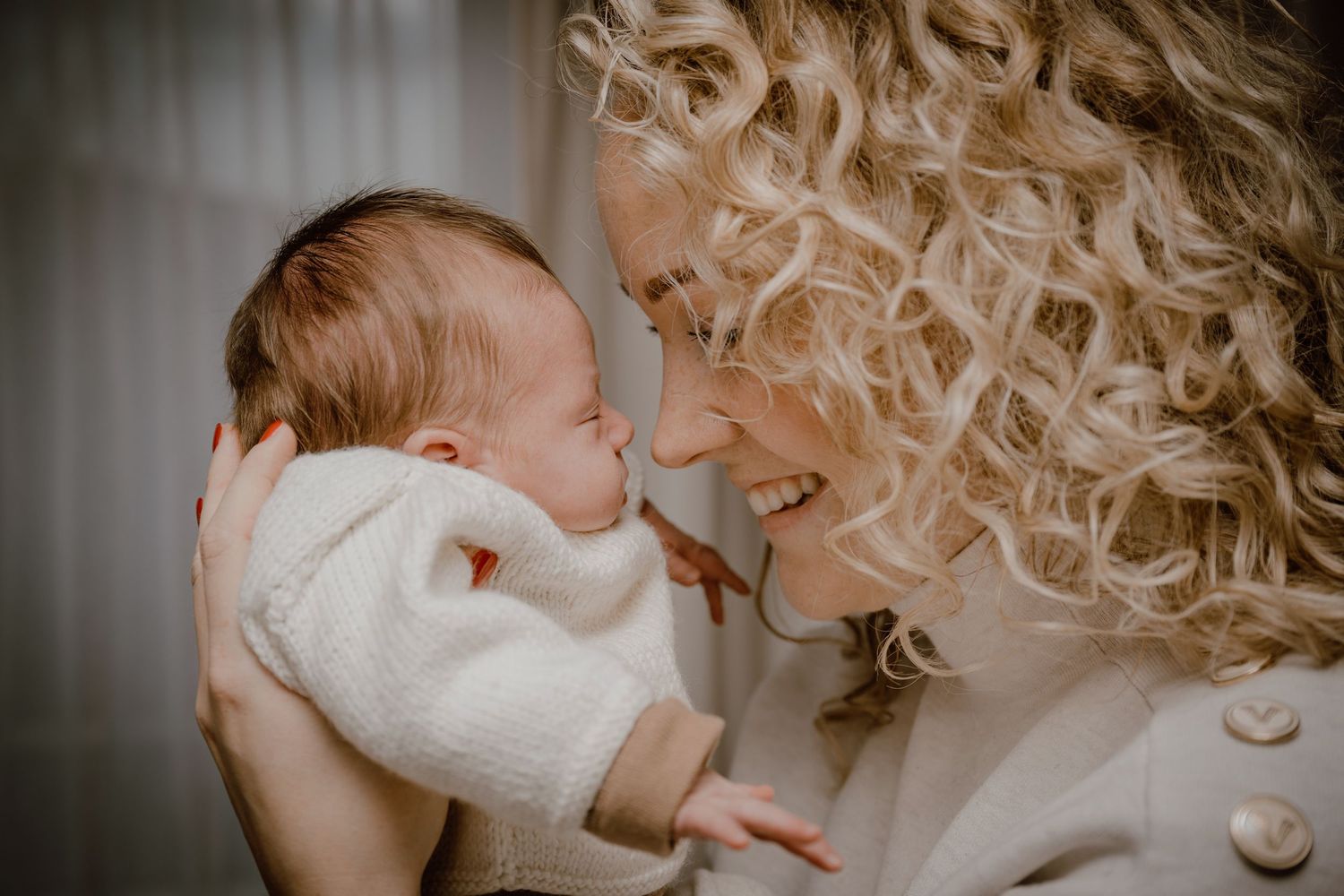 A series of seven intimate black and white photos showing tender moments between parent and newborn.