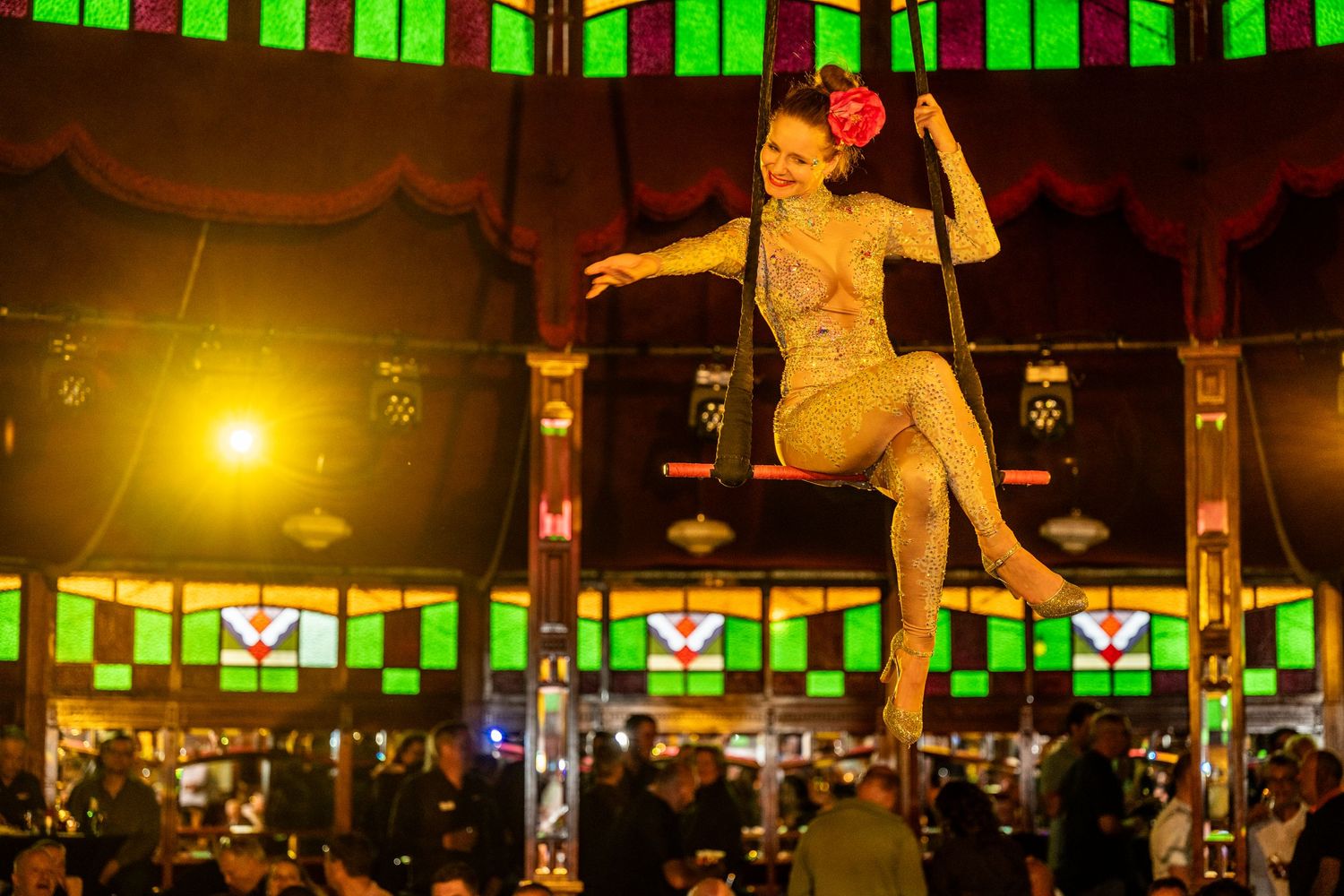 Dance performance in dimly lit venue with green lighting and silhouetted figures.