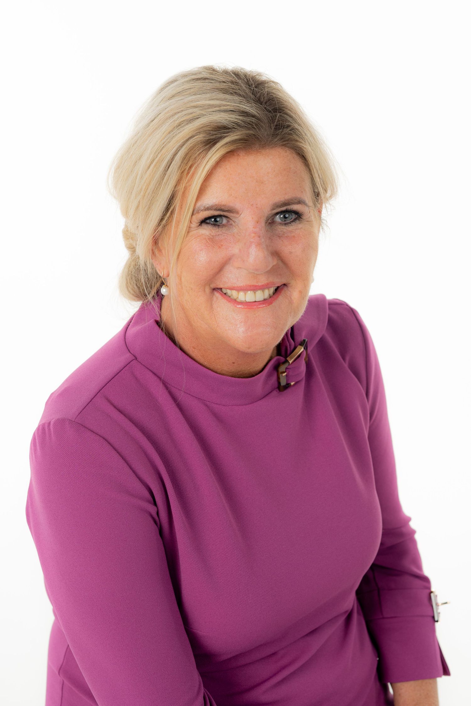 Professional headshots in magenta top showing warm expressions against white background.