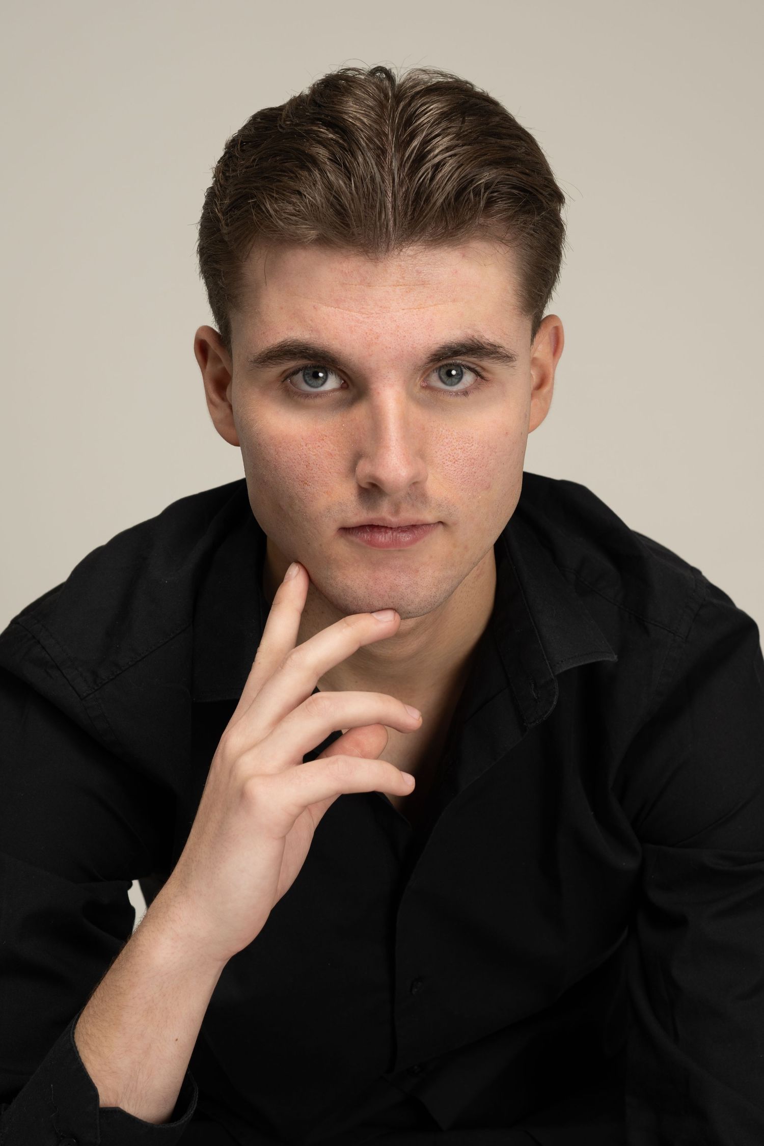 Moody portrait series in black clothing against neutral background with contemplative poses.
