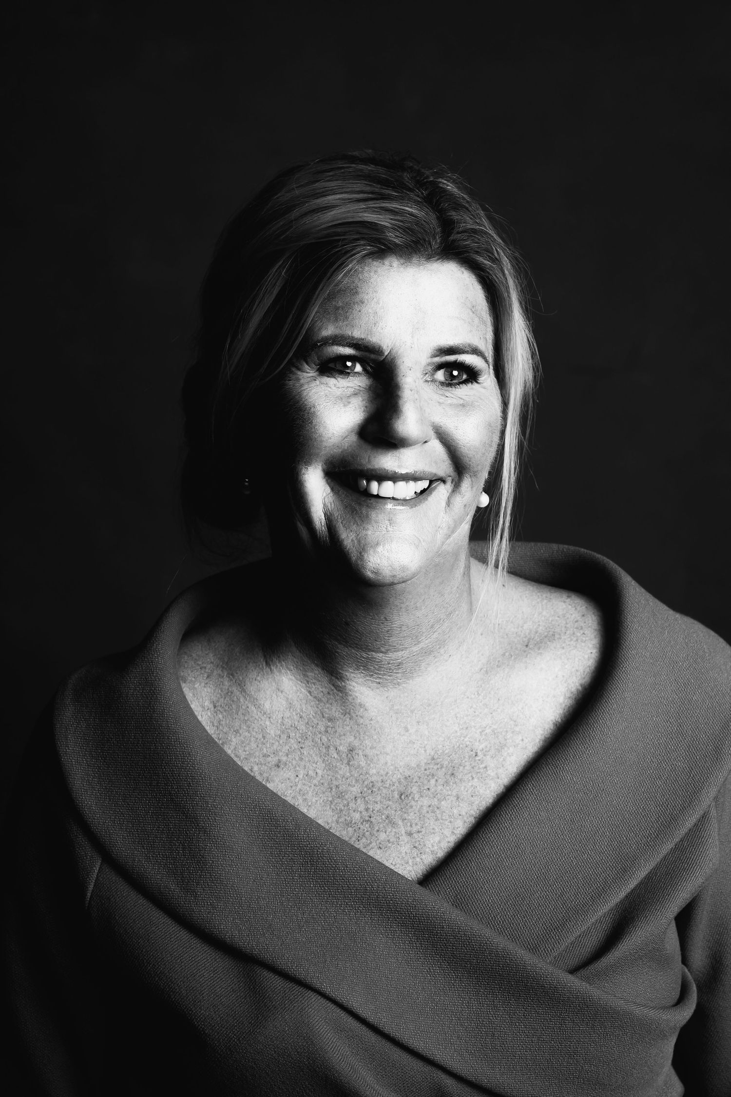 Black and white portrait series showing joyful expressions in dramatic lighting.