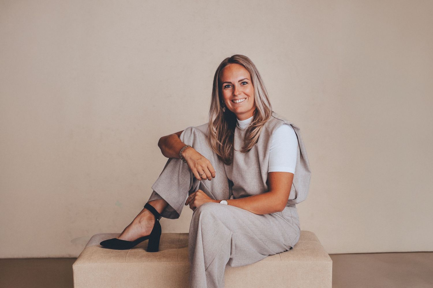 Professional studio portrait session with casual grey loungewear against neutral backdrop.