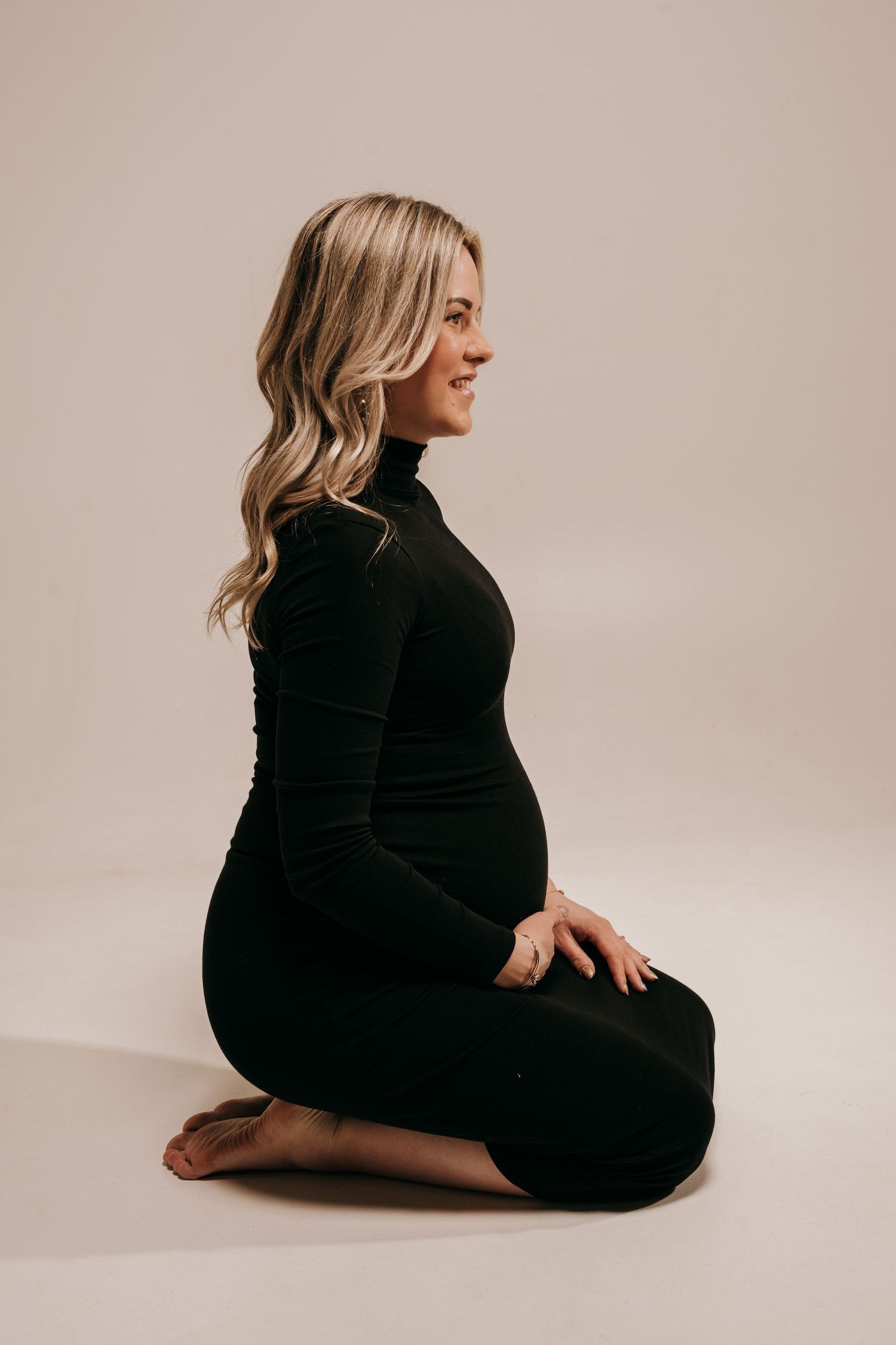 A series of minimalist studio portraits showing a person in black clothing seated against a light beige backdrop.