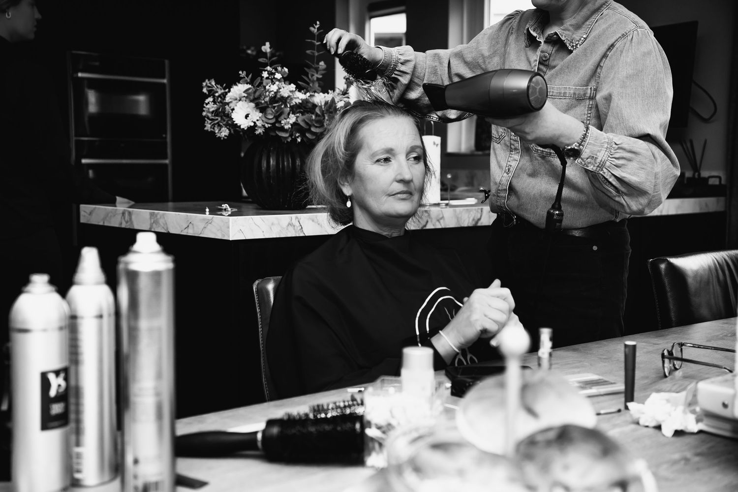 Black and white image of beauty preparation setup with styling products and tools.