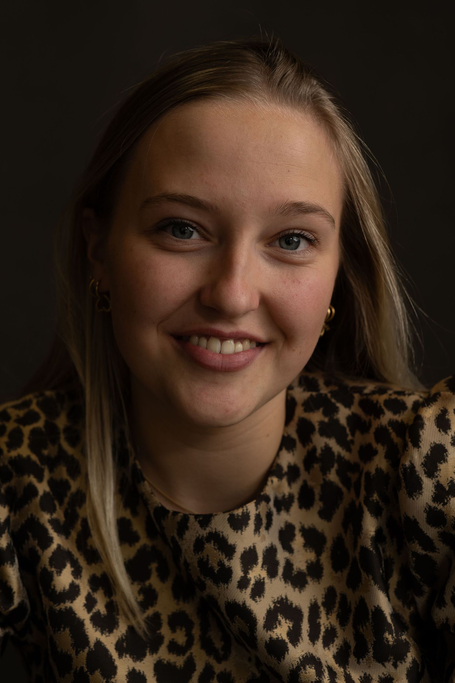 Cheerful portrait sequence in animal print top showing various expressions.