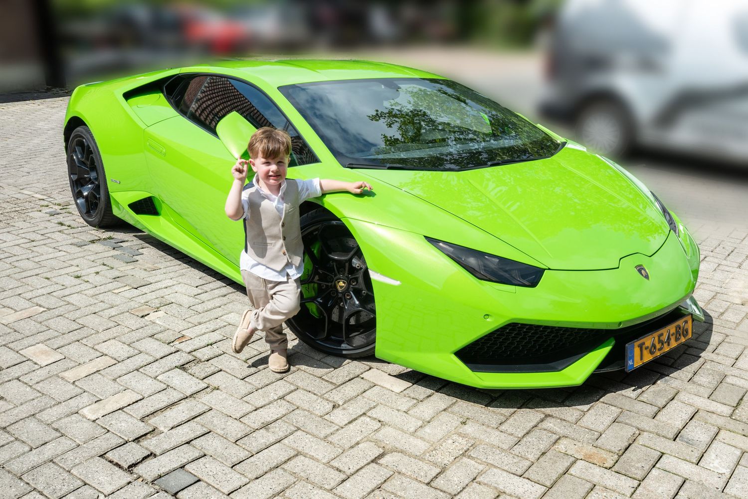 A bright green Lamborghini sports car parked on a stone driveway.