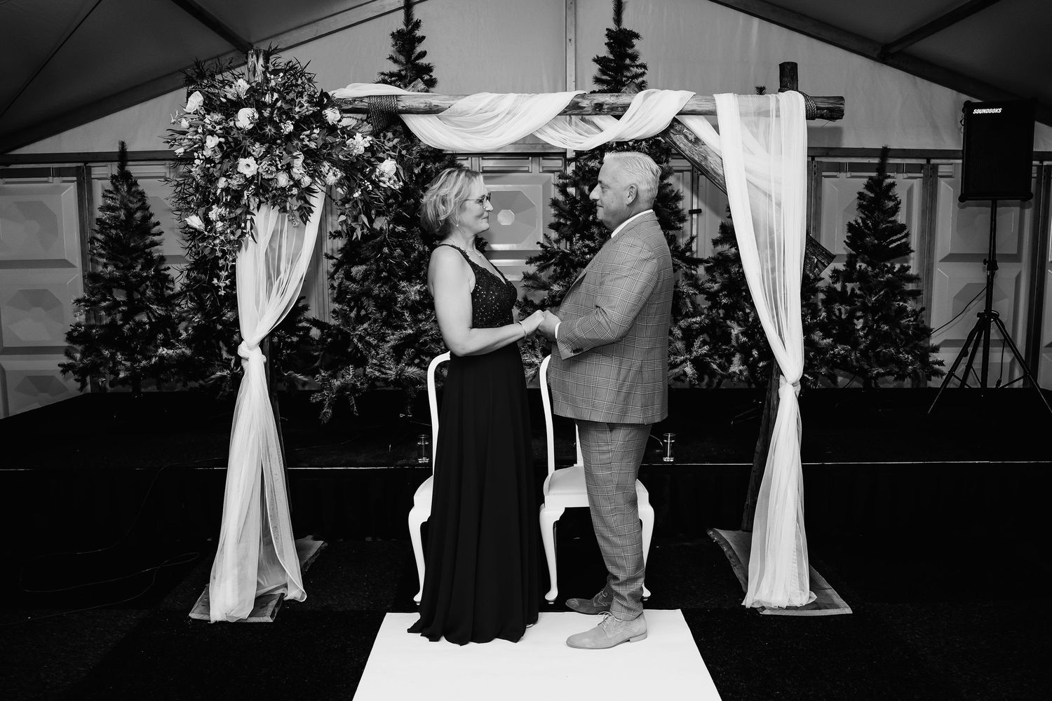 Wedding celebration under white tent with elegant draping and decor.
