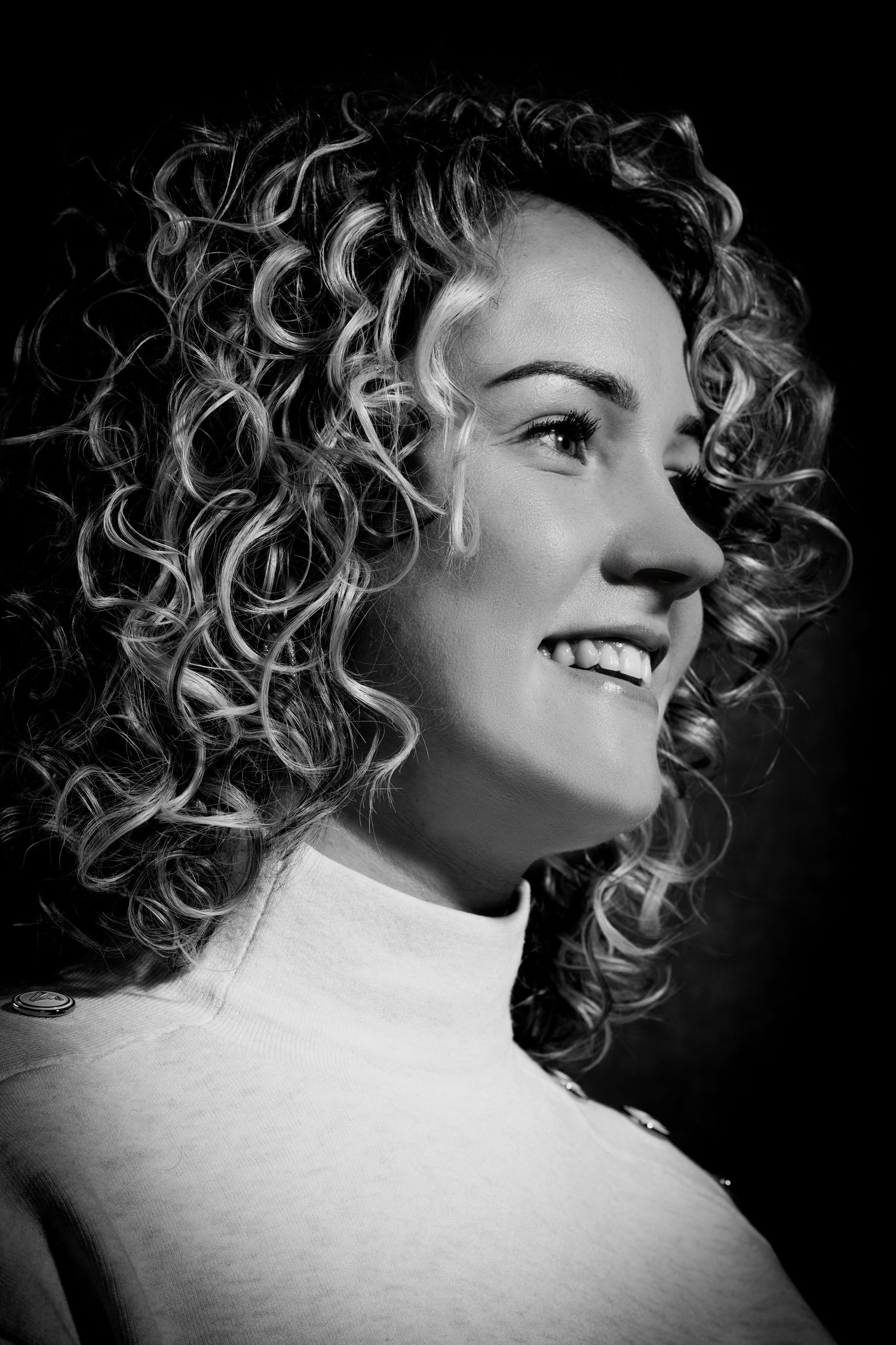 Black and white portrait featuring natural curly hair and a turtleneck sweater.