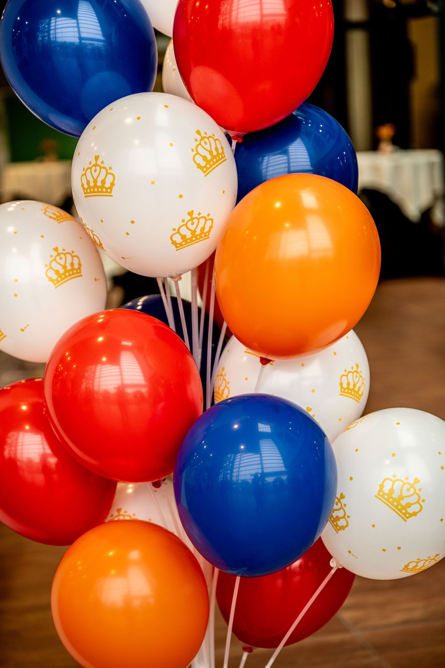 Colorful balloon display featuring red, white, blue, and orange balloons with golden crown designs.