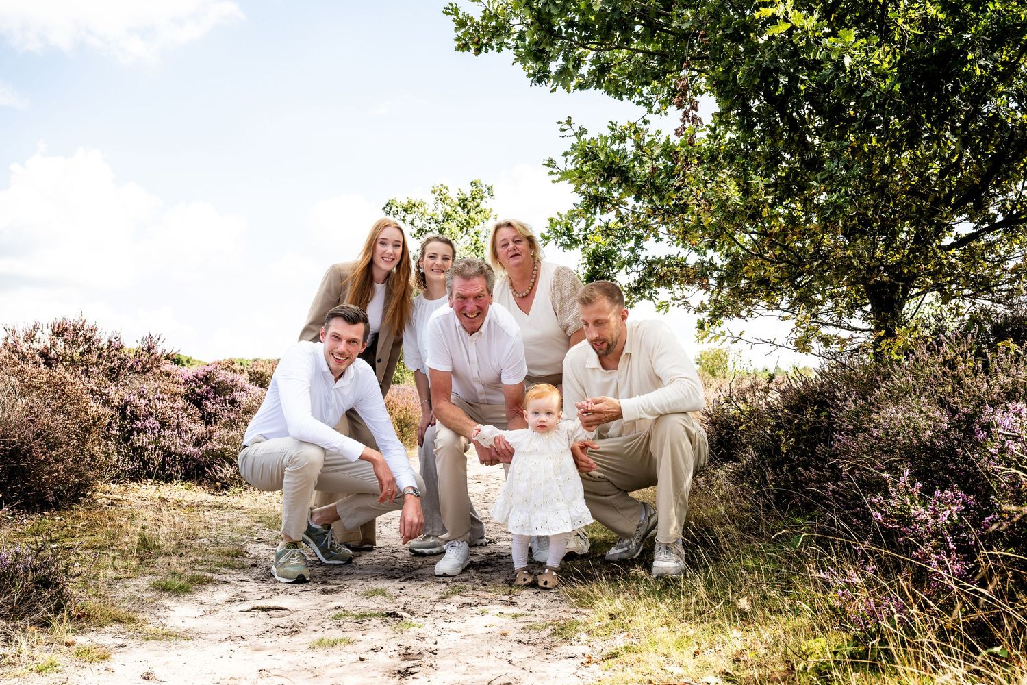 Family portrait session outdoors with natural lighting and white clothing.