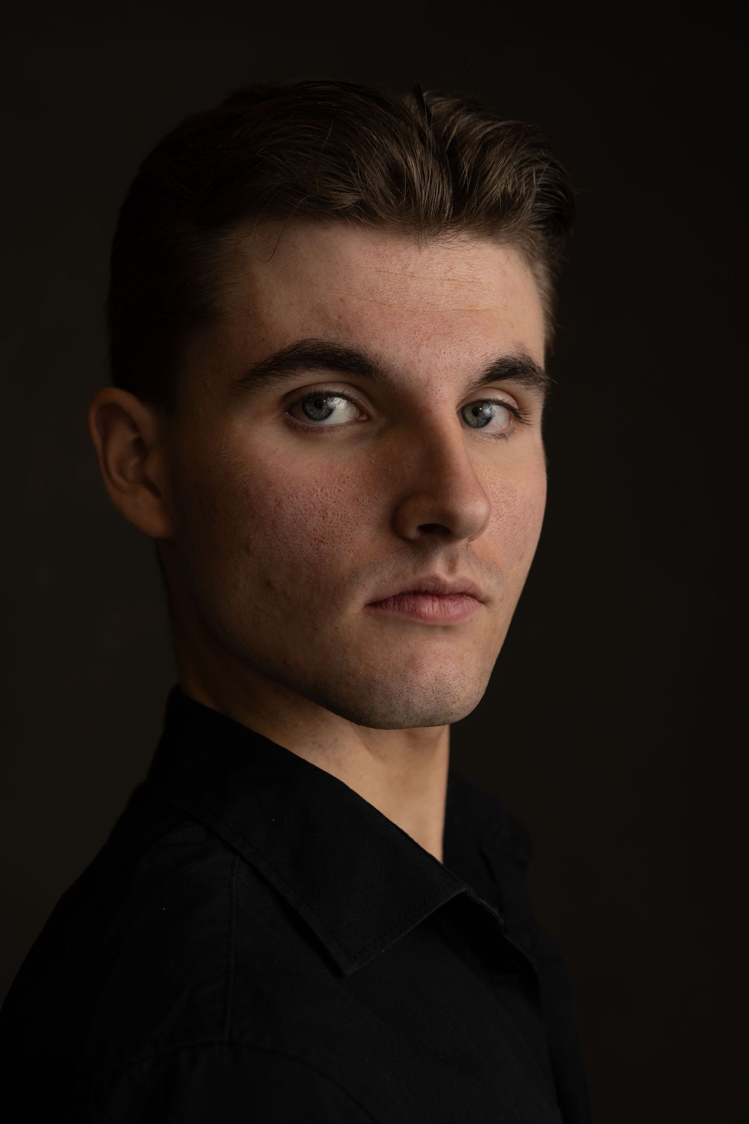 Dark and dramatic portrait series with strong shadows and side lighting.