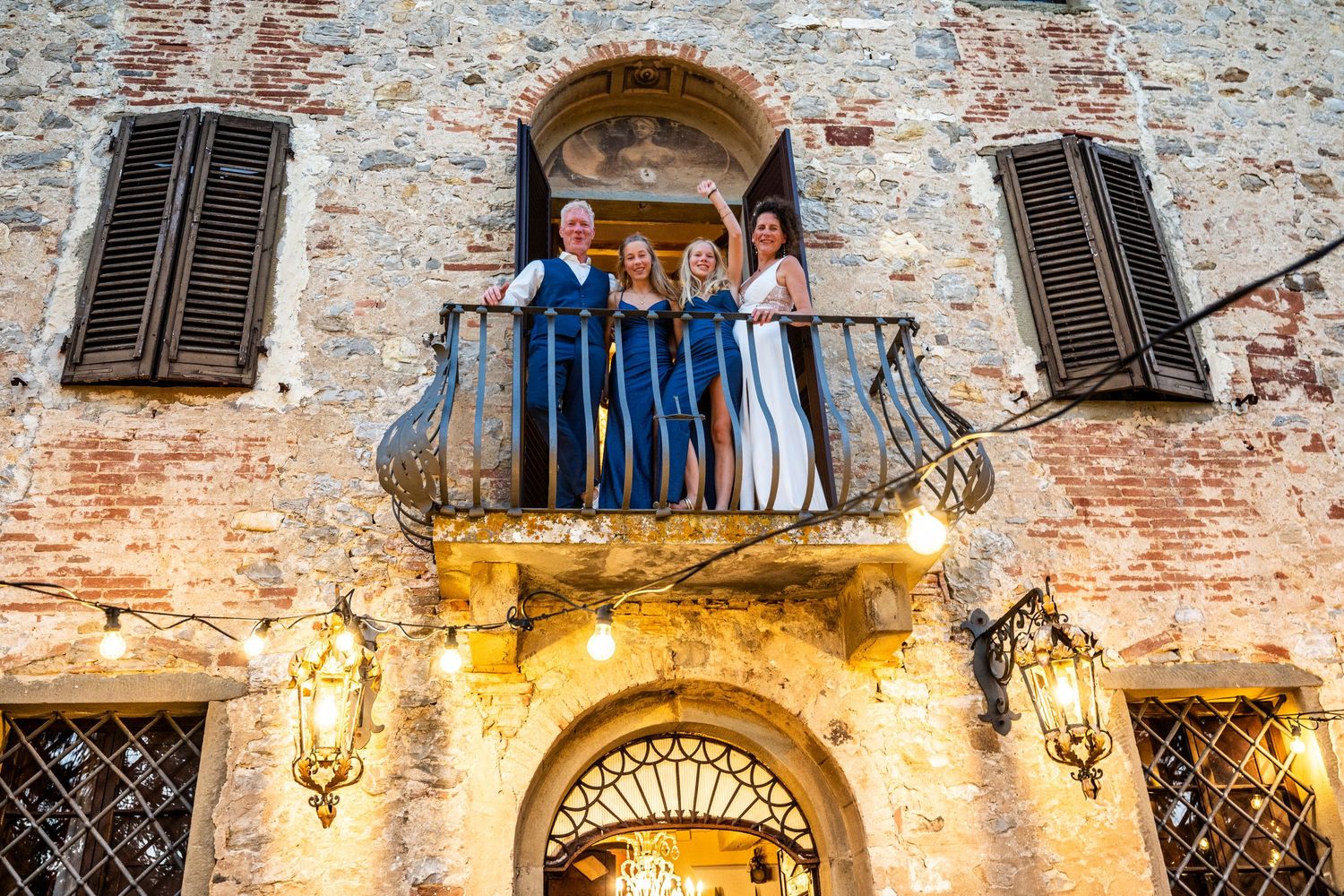 Historic stone building facade with arched windows and ornate architectural details lit by warm lighting.