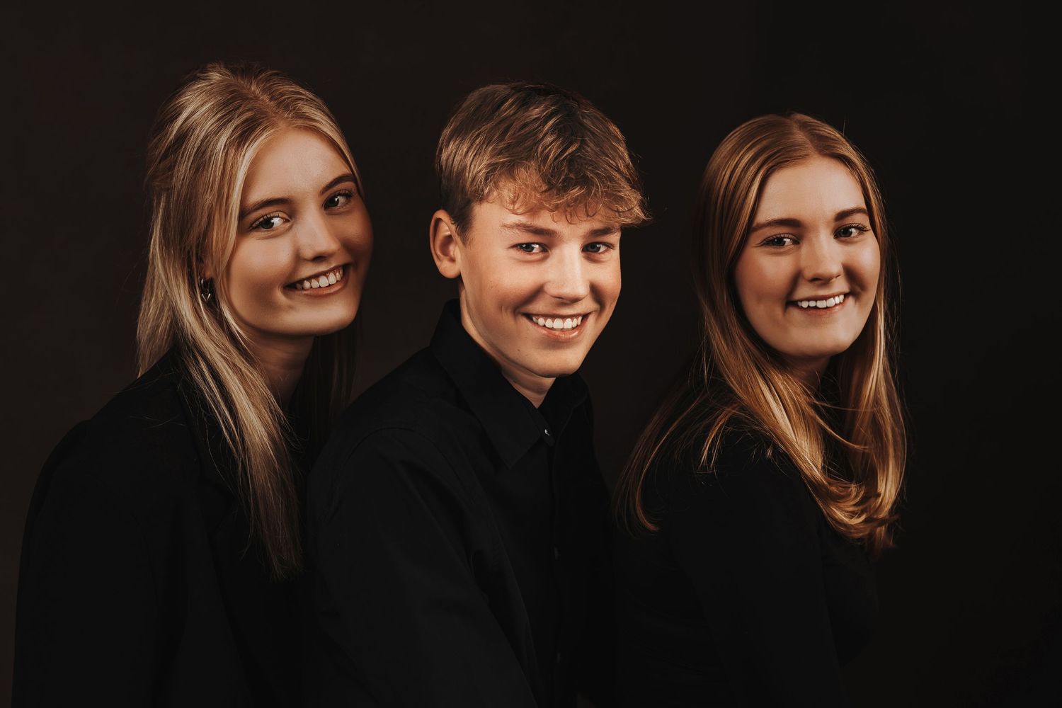Studio portraits against black background capture candid moments and natural interactions.