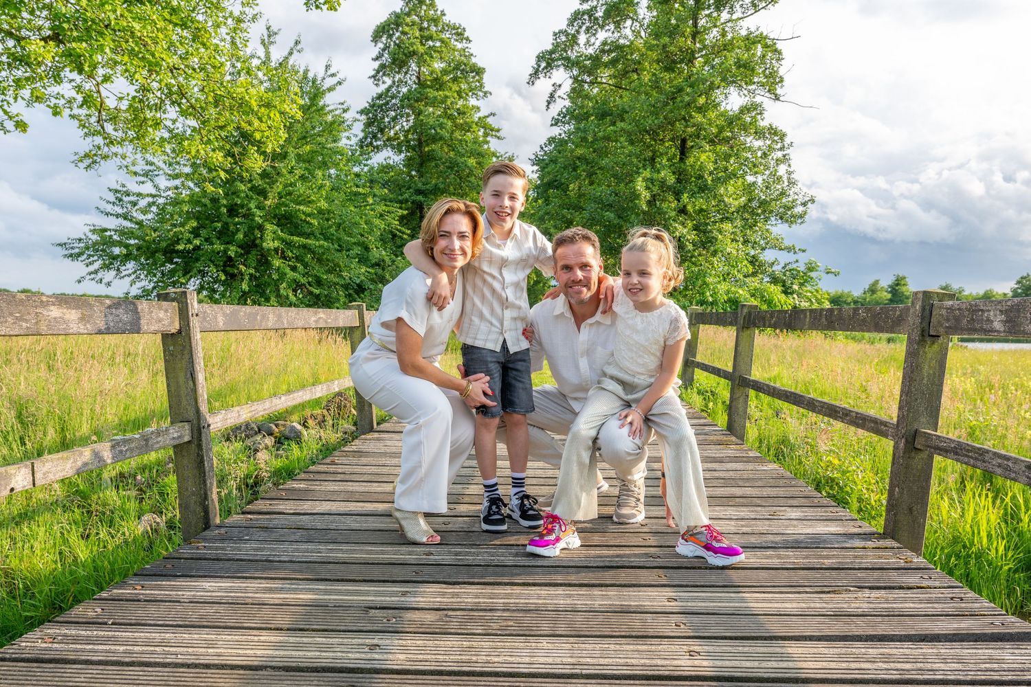 Family portraits on rustic wooden walkway in natural meadow setting.