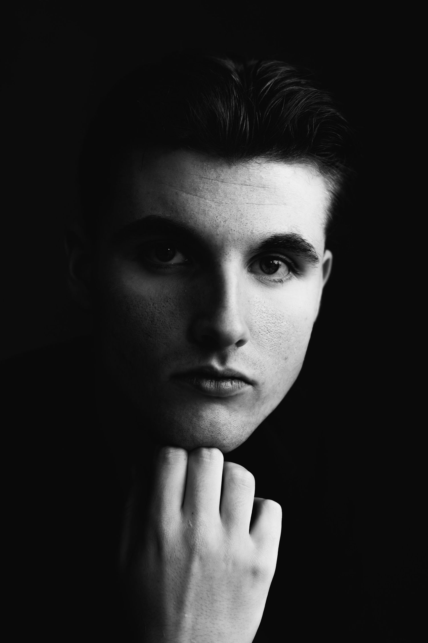 Black and white portrait series with dramatic shadows and hand gestures.