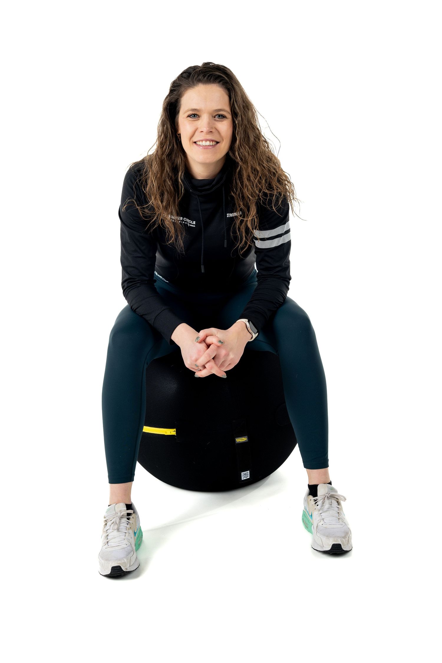 Athletic figure in black activewear demonstrating squatting positions against white background.