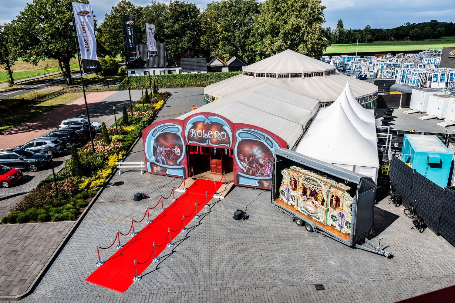 Aerial view of outdoor event space with red carpet and white tents.