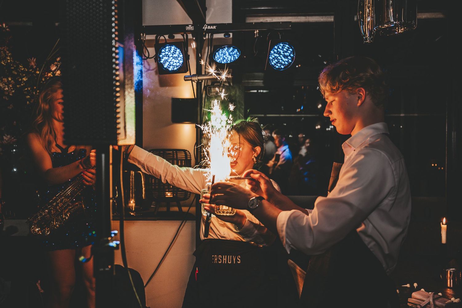 Dark atmospheric venue with blue lighting and silhouettes creating a moody ambiance.