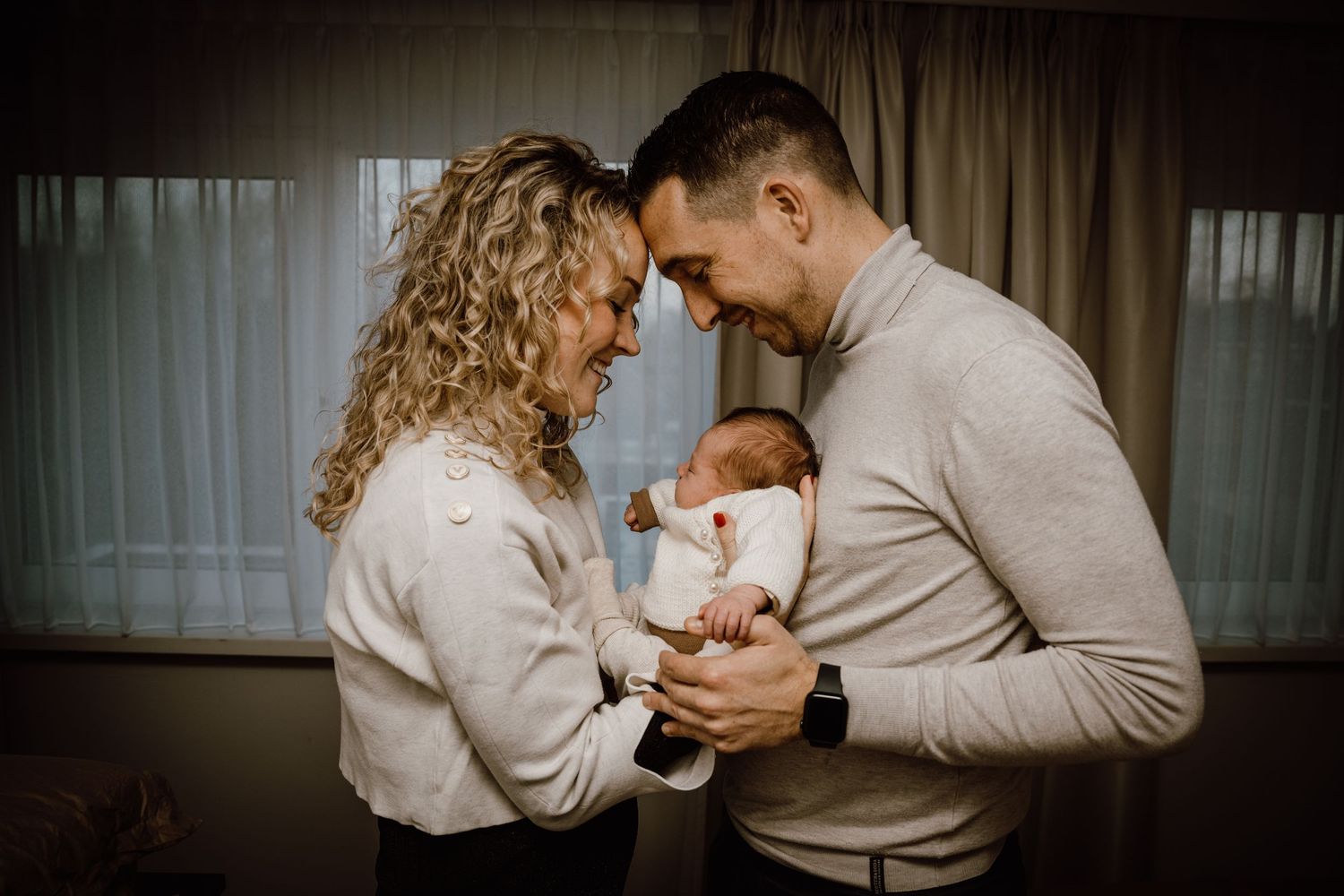 A tender family moment captured in a series of intimate photos showing parents bonding with their newborn baby.
