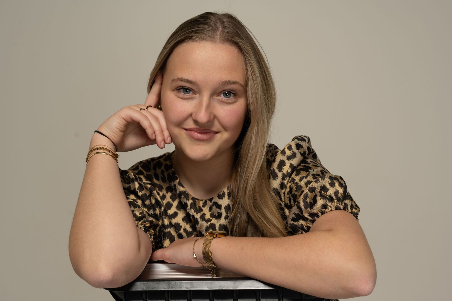 Studio portraits in leopard print showing warm, friendly expressions against light background.