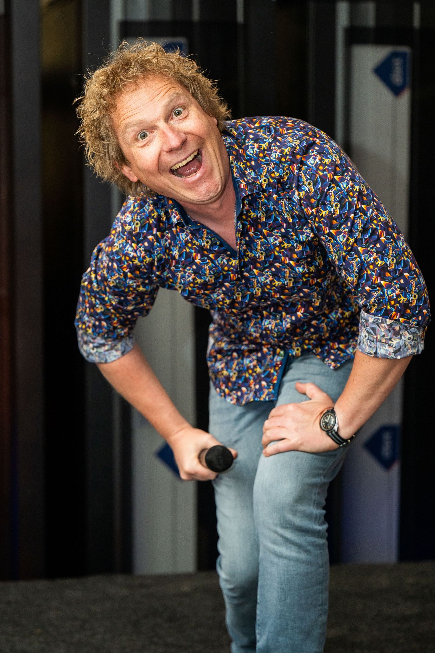 Dynamic sequence of expressive poses in colorful floral shirt against dark background.