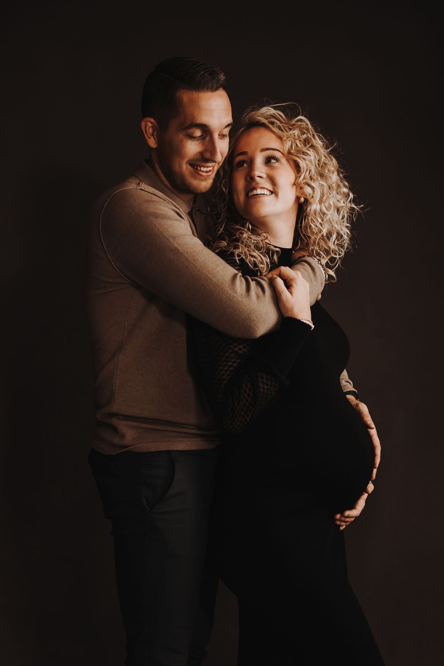 Romantic couple photography session in moody dark lighting with natural expressions.