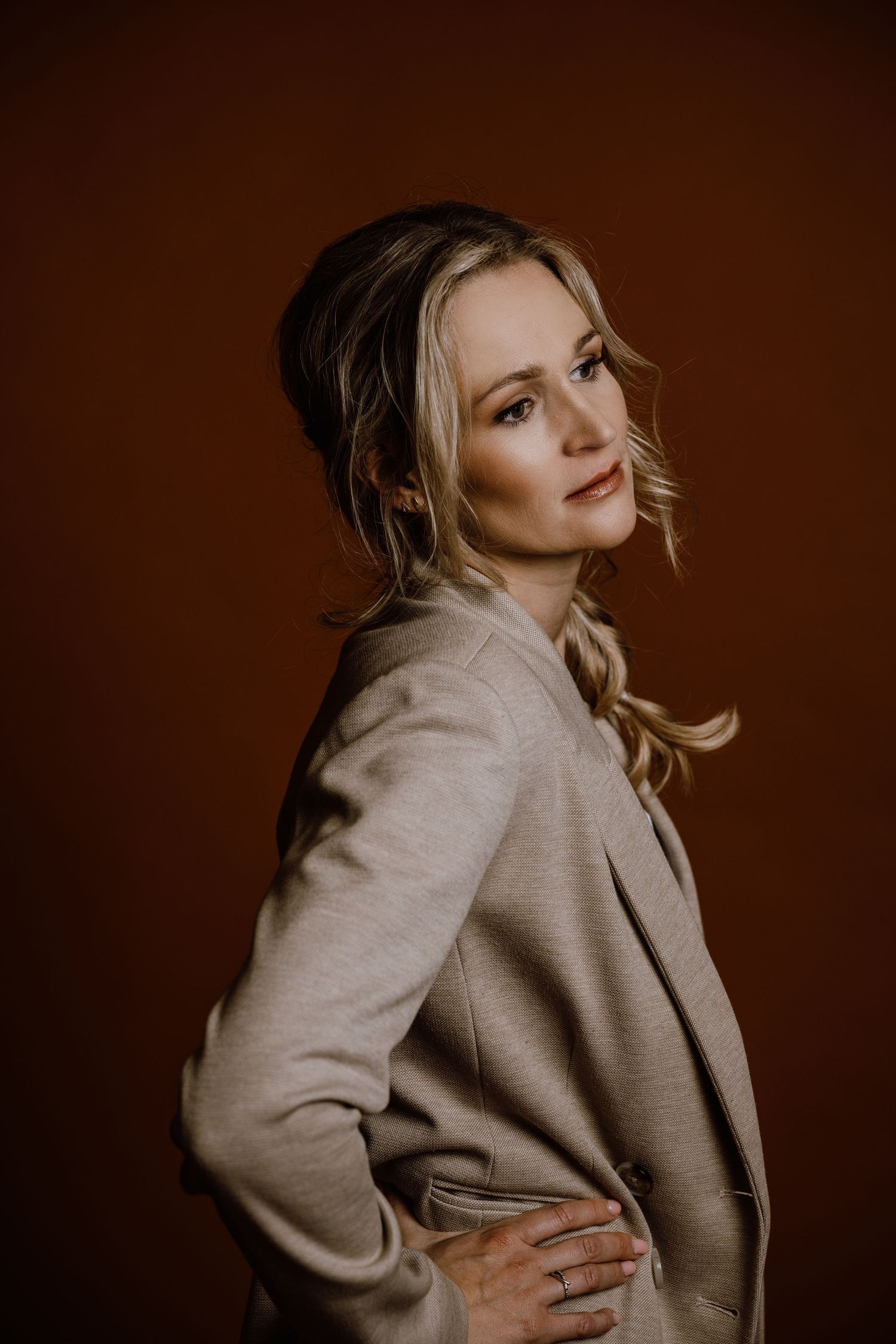 Artistic portrait series in beige sweater against warm brown background.