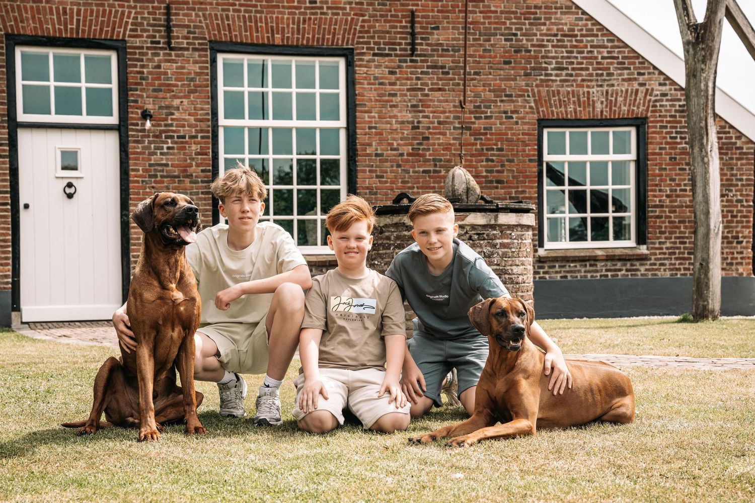 Casual family photos with dogs outside historic brick building.