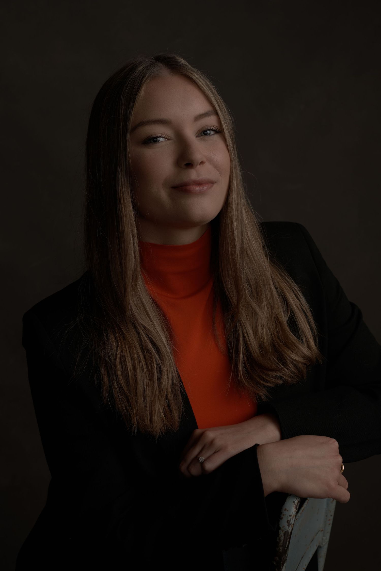 Dramatic portrait series in dark lighting with person wearing orange turtleneck.