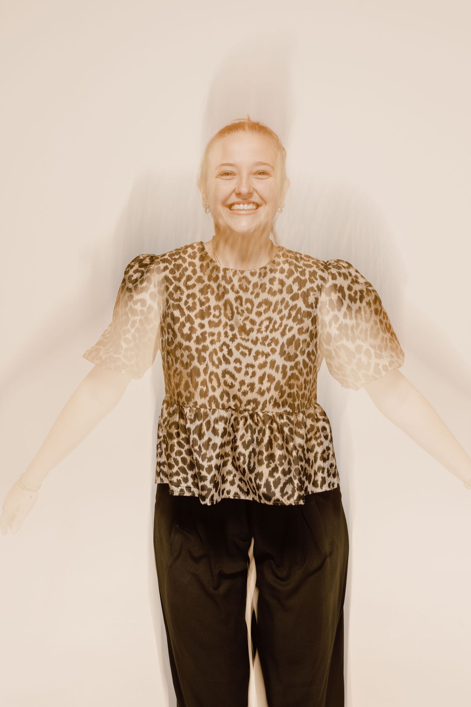 Person wearing a leopard print top and black pants shown in multiple poses against white background.
