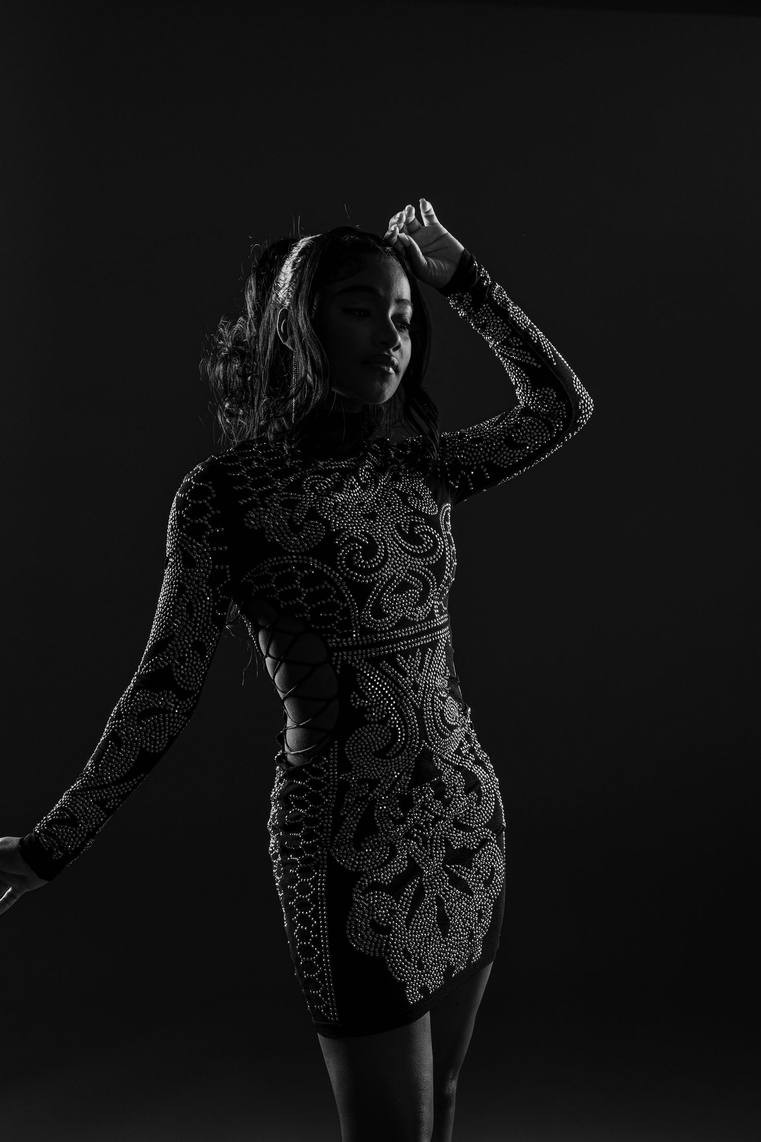 Birthday portrait. BW photo. Model is posing with one hand on head, and the other hand away from back.