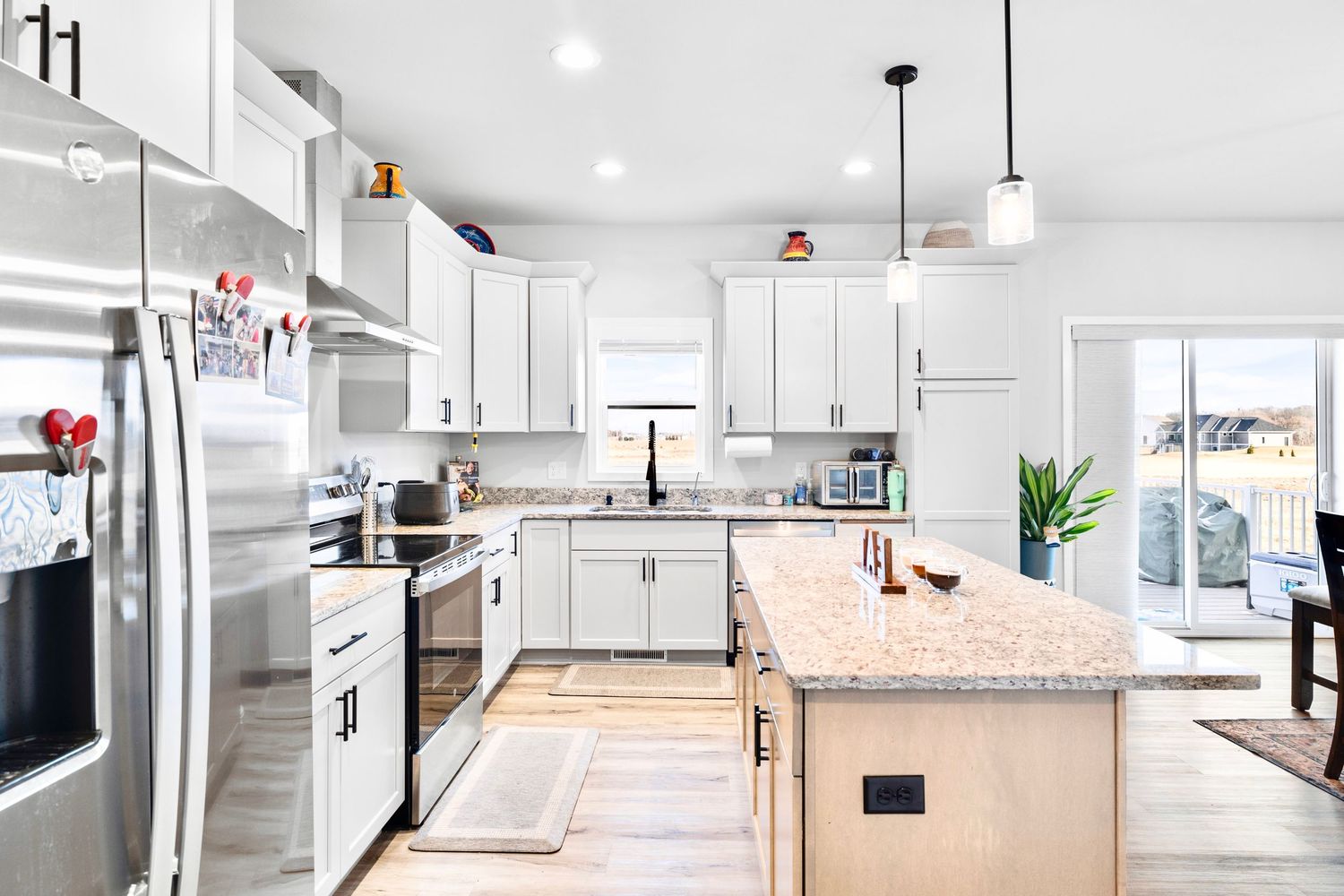 Kitchen, refrigerator, island, counters and cupboards, stove, and sink