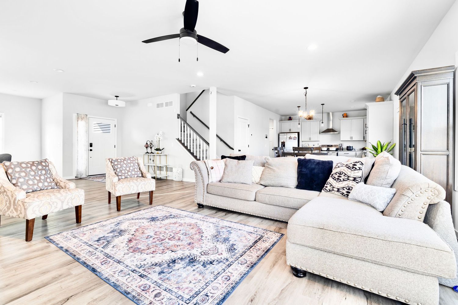 Living Room with furnitures, chairs, rug, accent table, stairs, and front door,