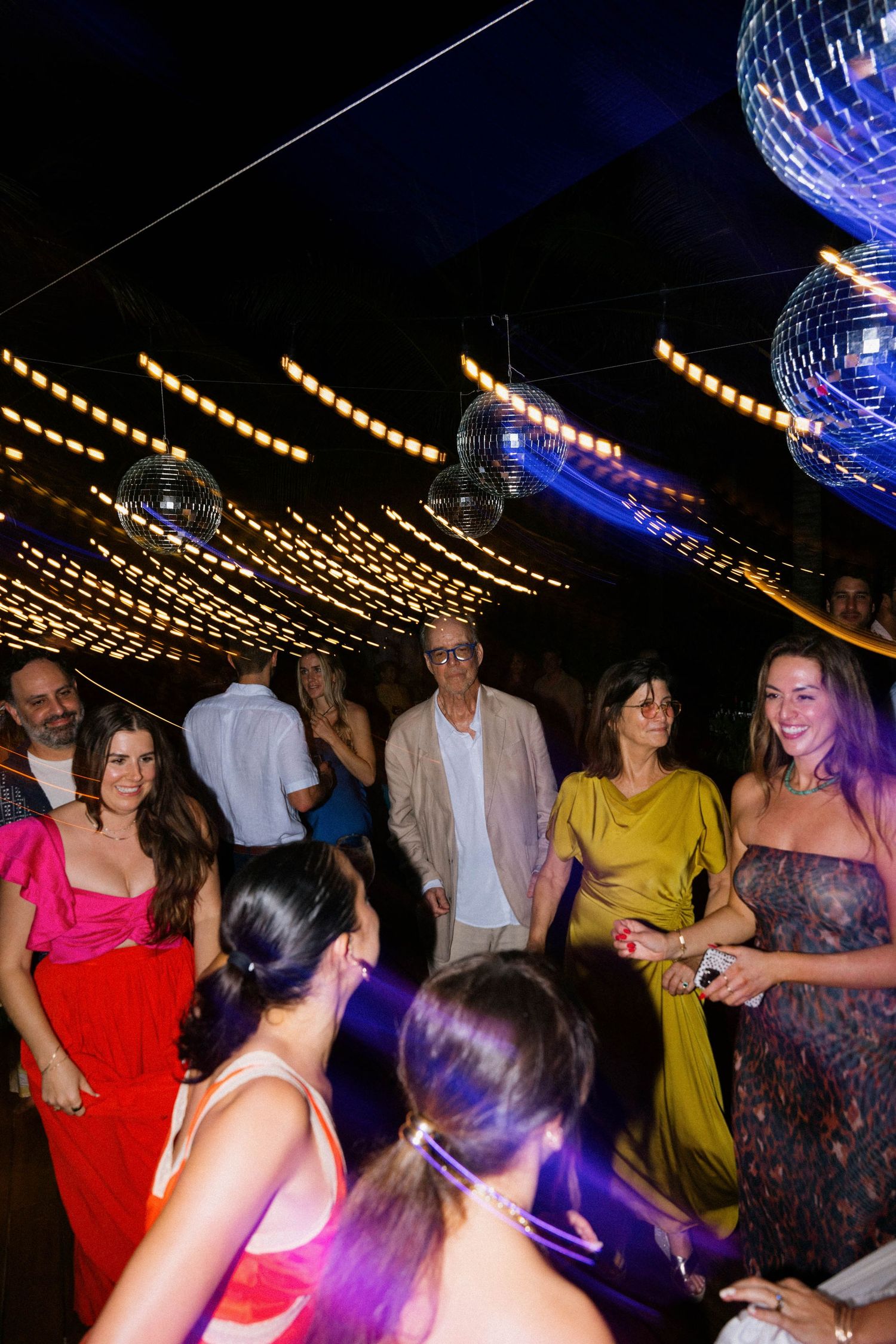 Vibrant party scene with string lights and disco balls creating a festive atmosphere.