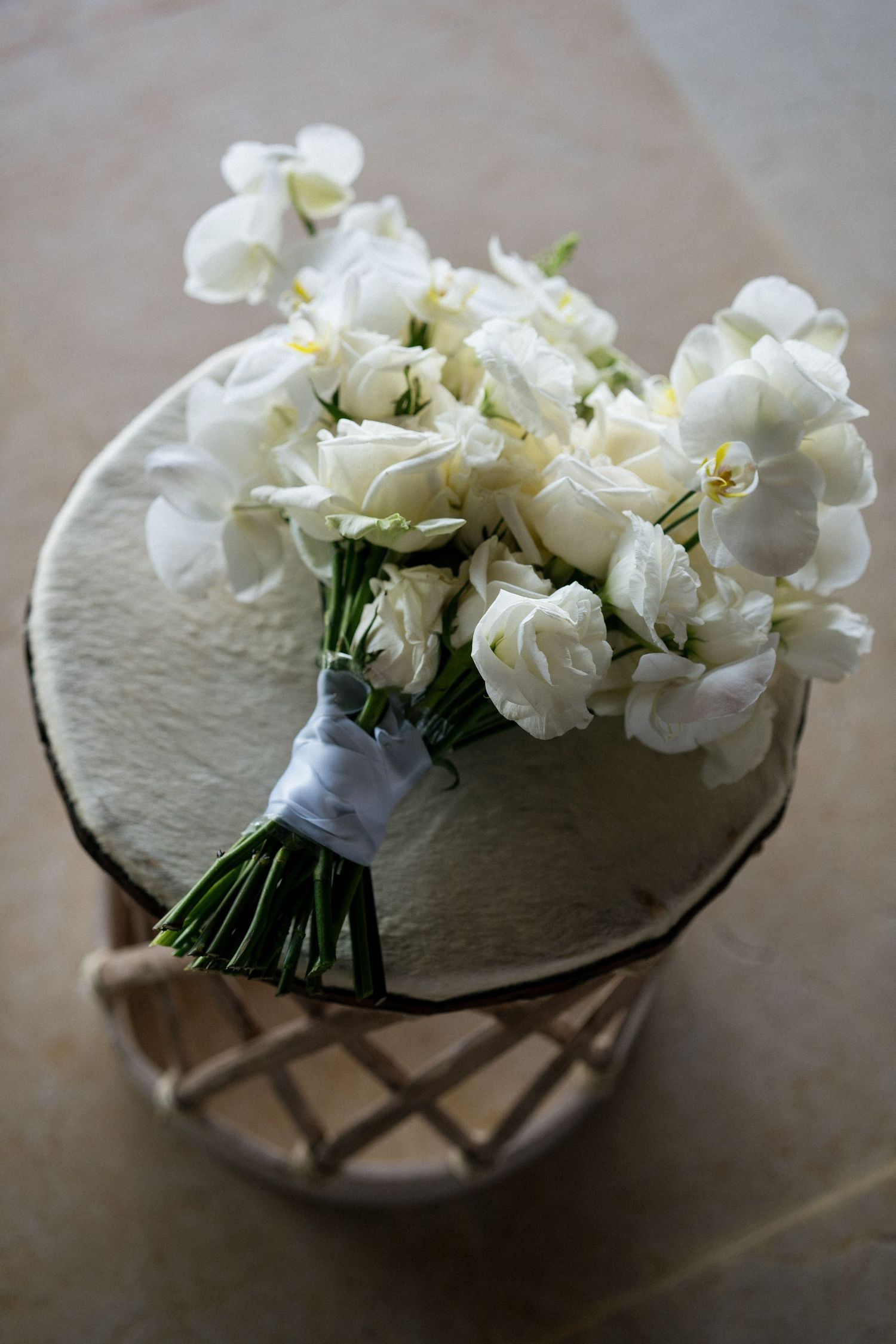 Delicate white floral bouquet arrangement displayed in a decorative glass vase.