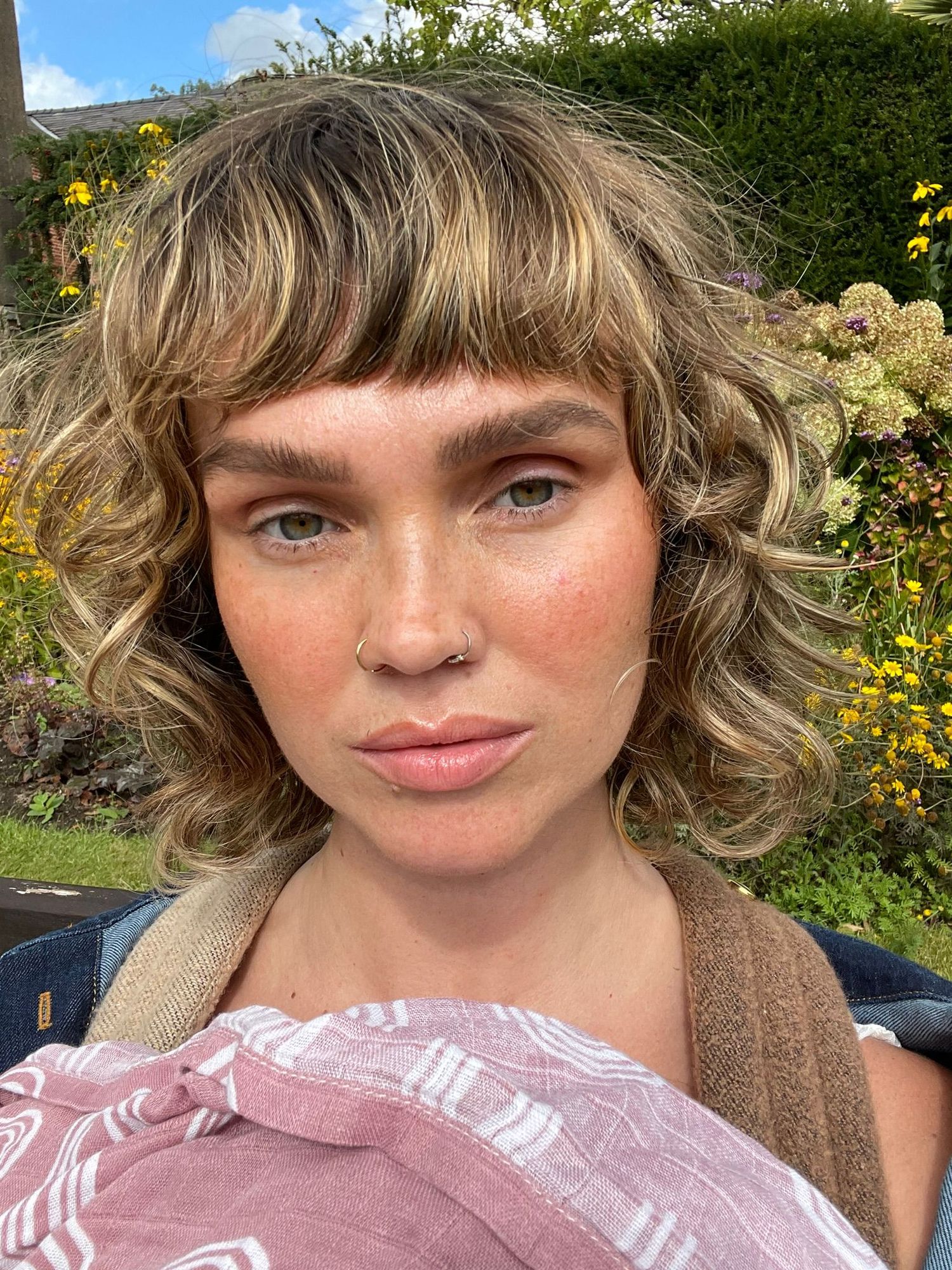A series of outdoor selfies in front of a garden with yellow flowers and greenery in the background.