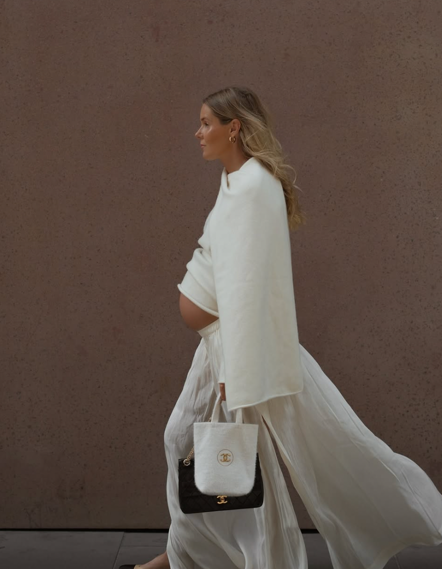 A series of dynamic fashion shots showing a model in flowing white garments against a textured brown wall.