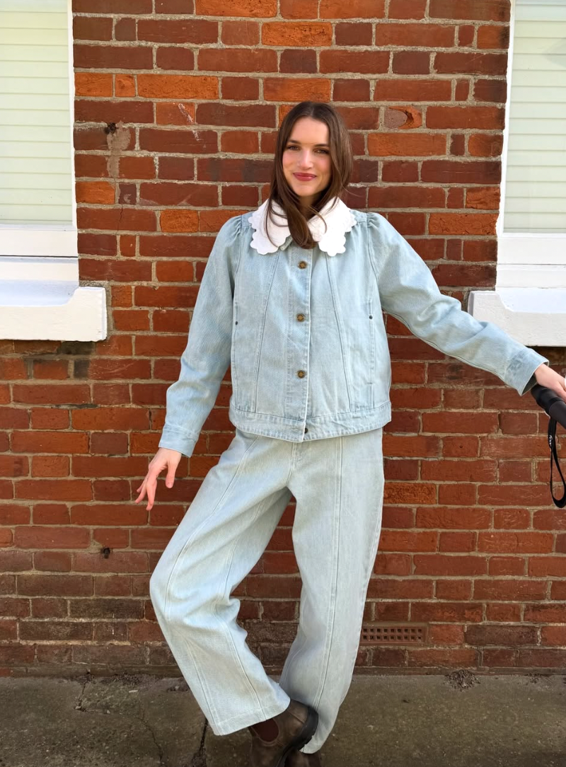 A series of four fashion poses against a brick wall showing light denim coordinates in a retro style.