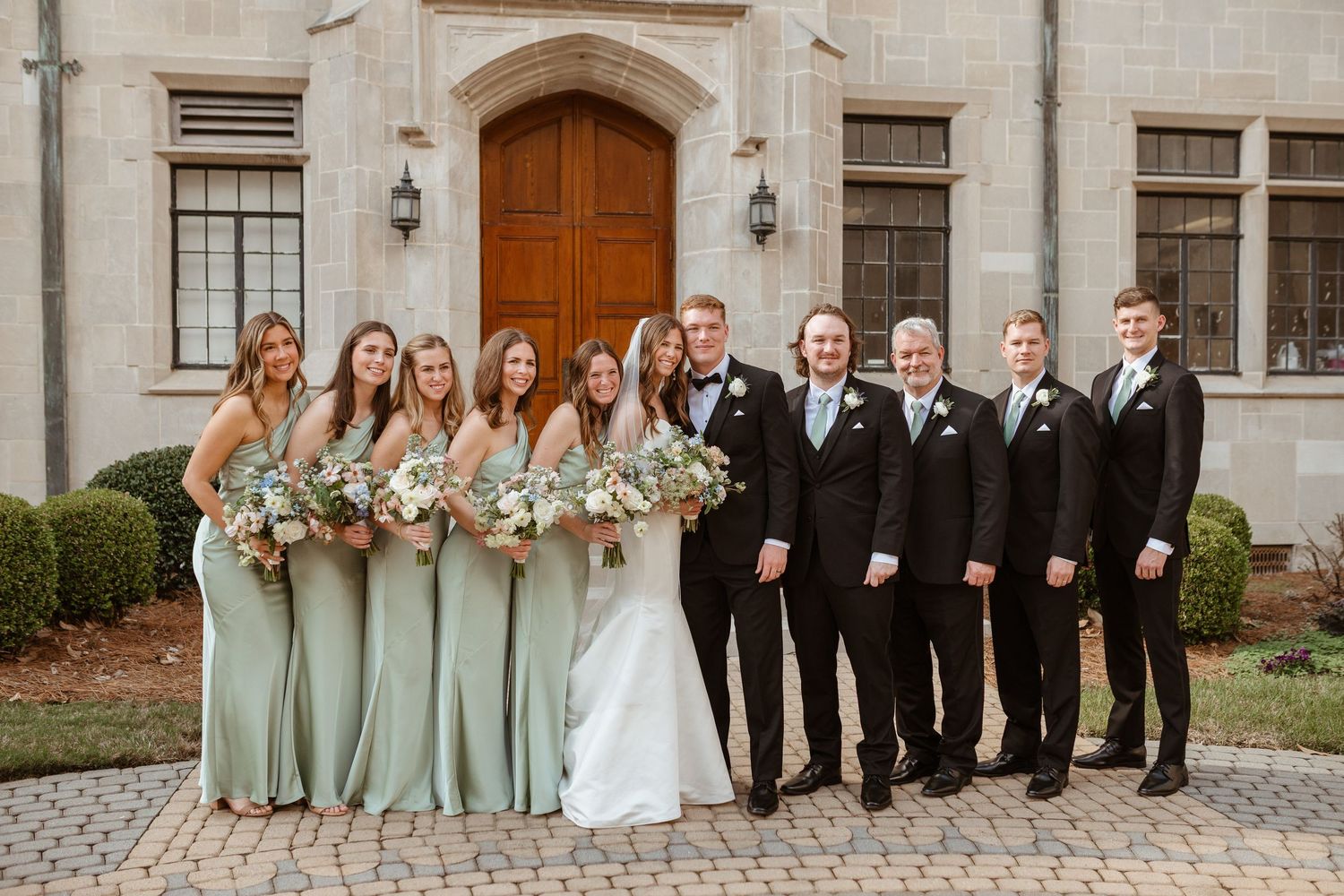 Bridal party posing together on wedding day.