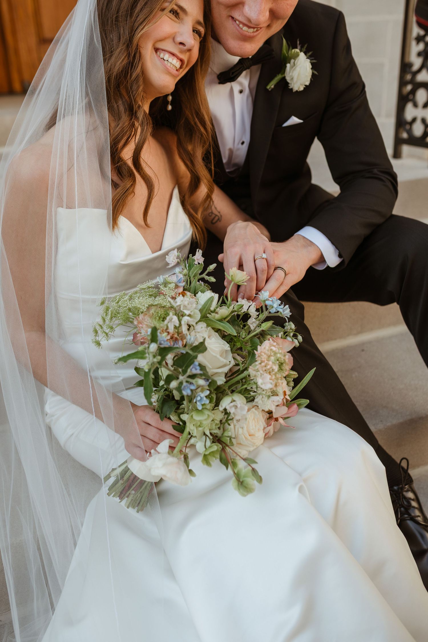 Bride and groom smiling and holding hands on their wedding day.